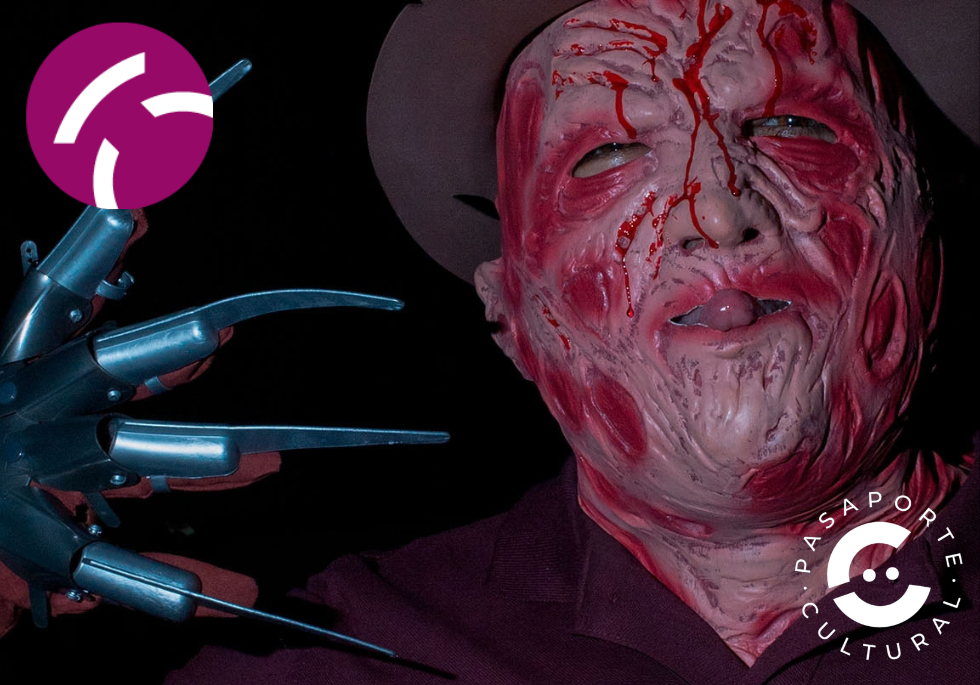 Primer plano de una persona disfrazada con máscara facial roja y sangrienta y guante de cuchillas metálicas.